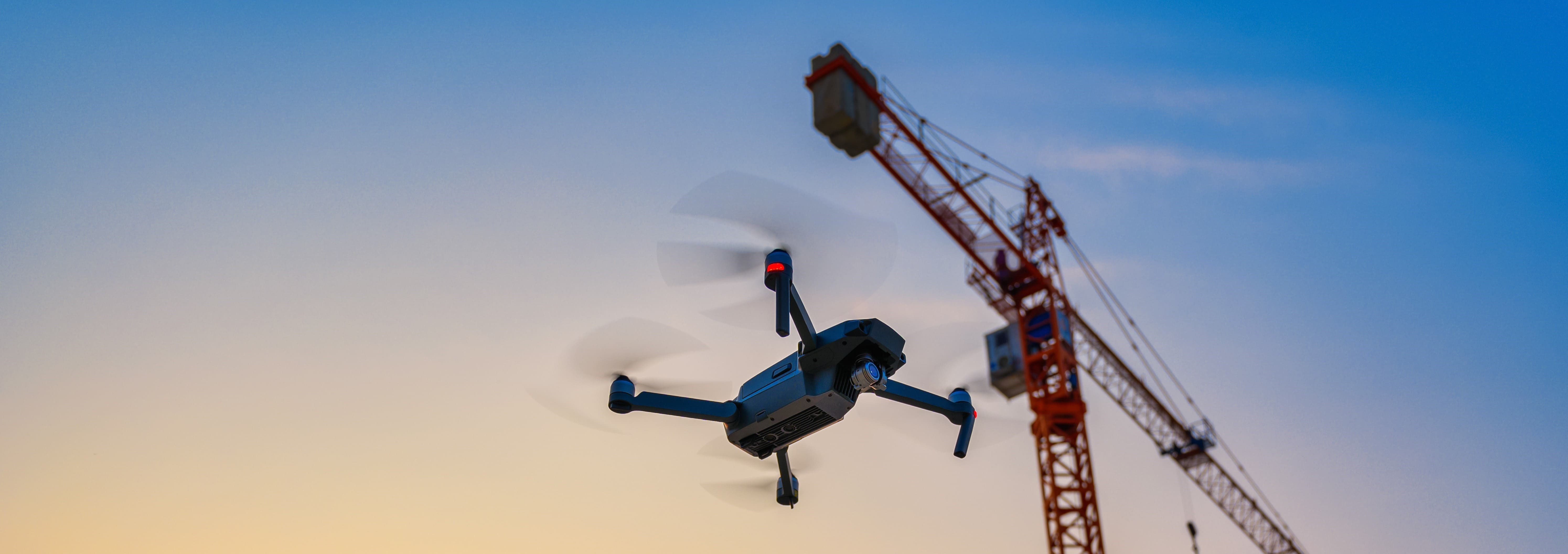 Eine Drohne fliegt neben einem Kran Titelbild: Eine Drohne fliegt neben einem Kran